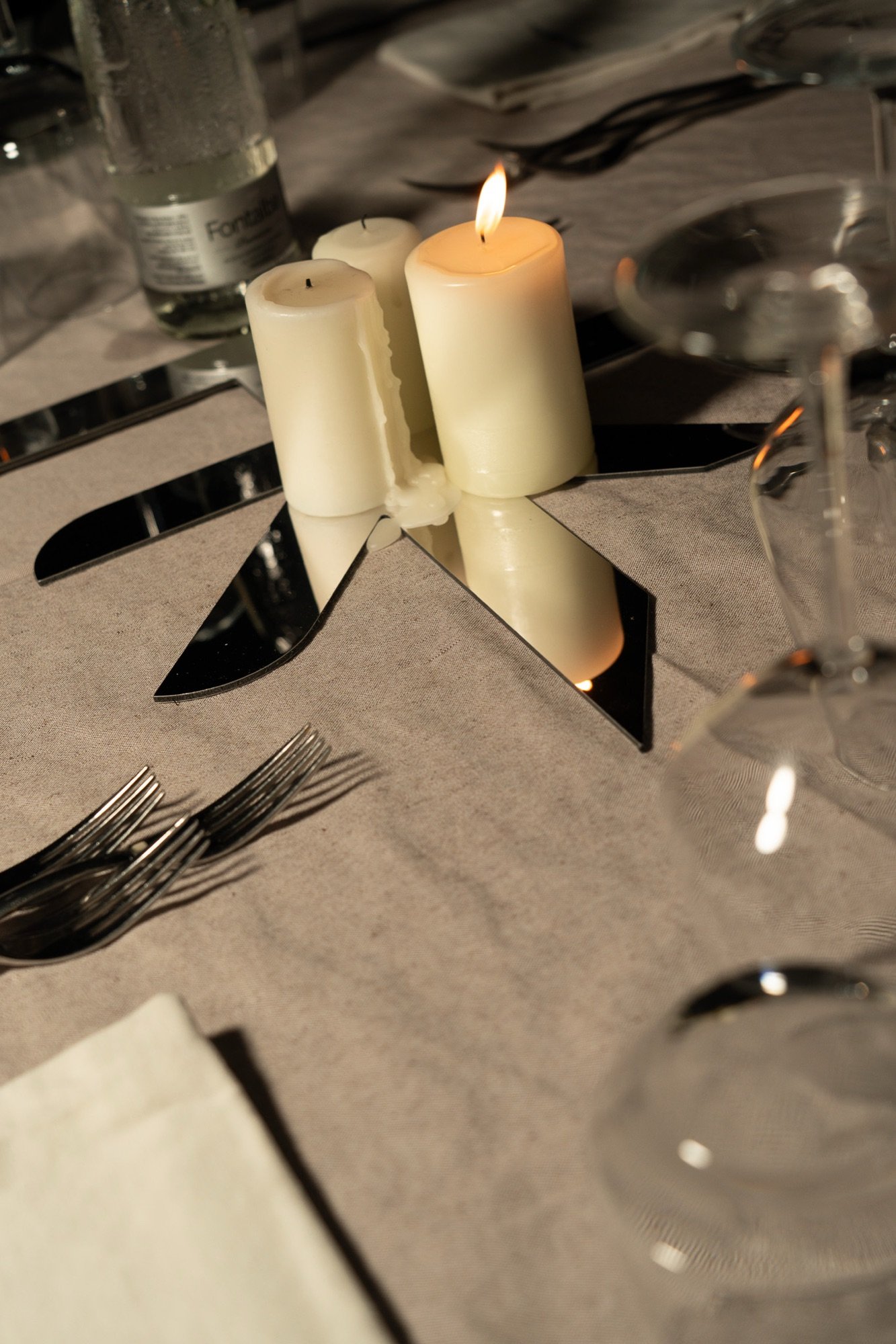 Candlelit table setting at the Bellavista dinner, mirrored place cards and glassware