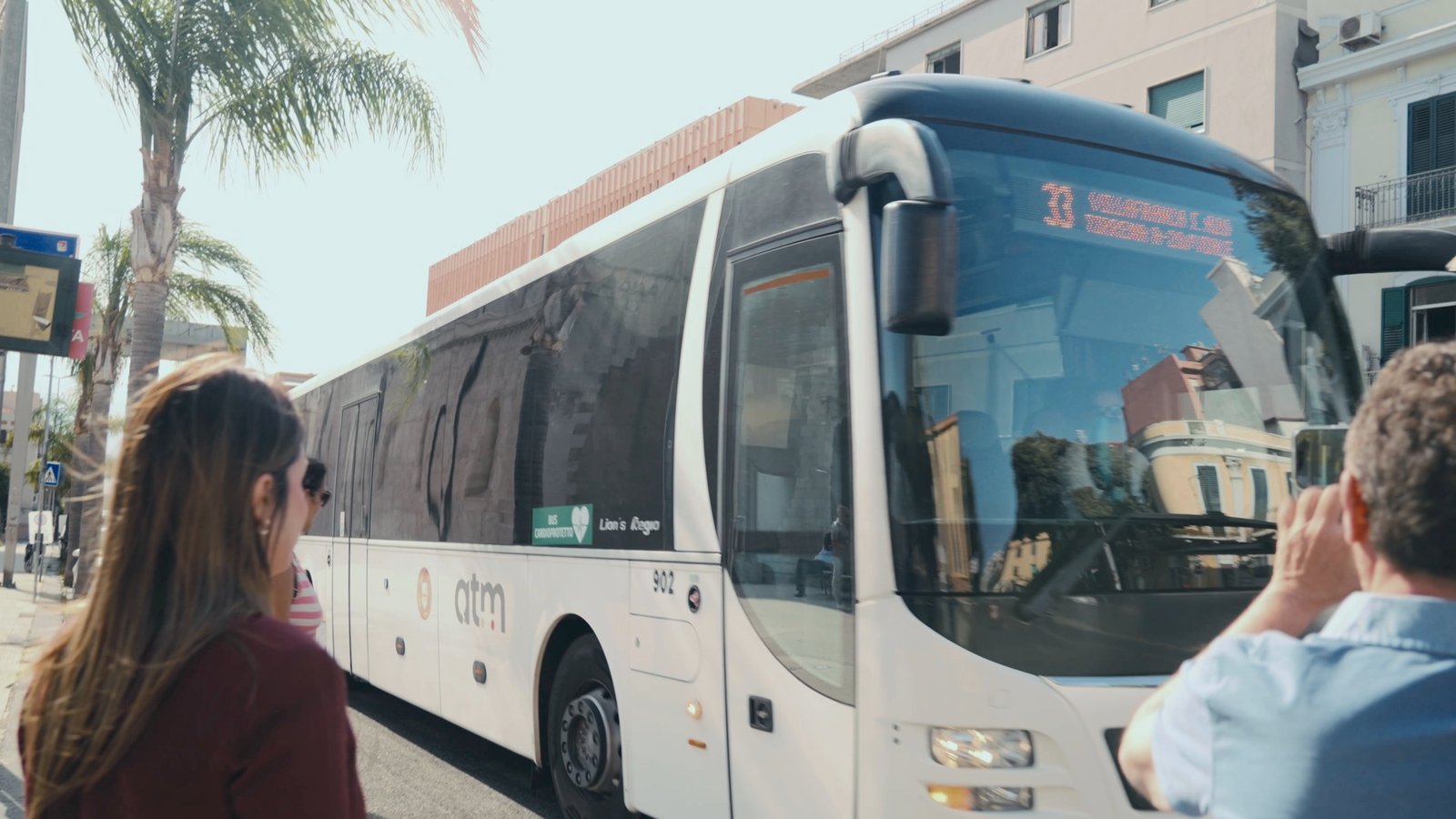Un autobus urbano ATM Messina alla fermata, con passeggeri in attesa di salire