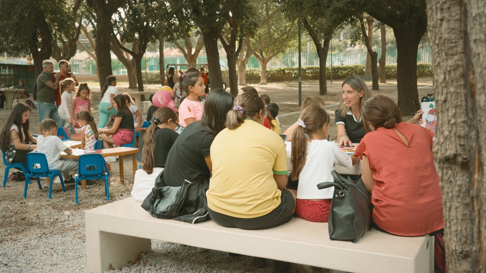 Famiglie e bambini seduti sotto gli alberi a un evento pubblico ATM Messina sulla mobilit&agrave;