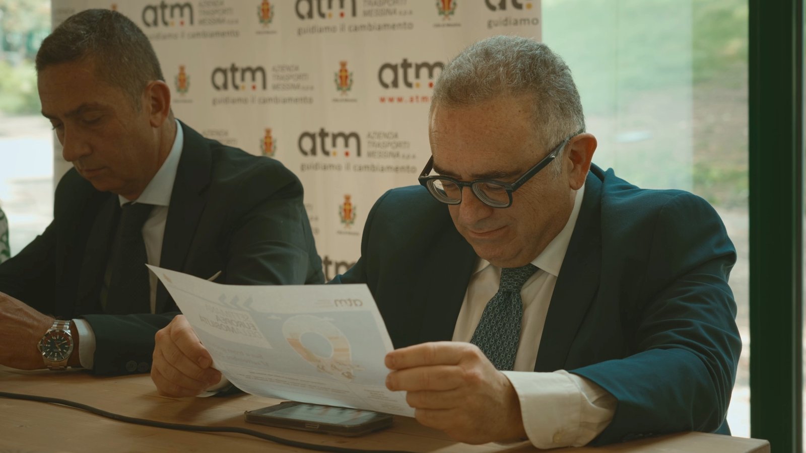 I fogli del programma del festival letti davanti a un fondale brandizzato ATM Messina