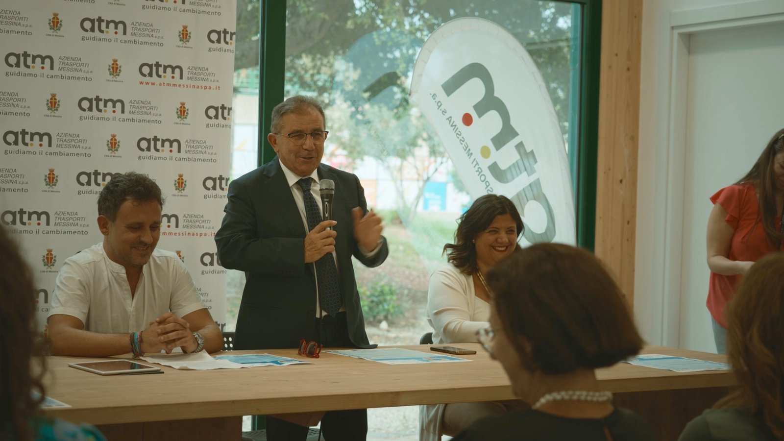 Tavolo dei relatori e pubblico a una conferenza sulla mobilit&agrave; di ATM Messina, con il brand aziendale sul fondale
