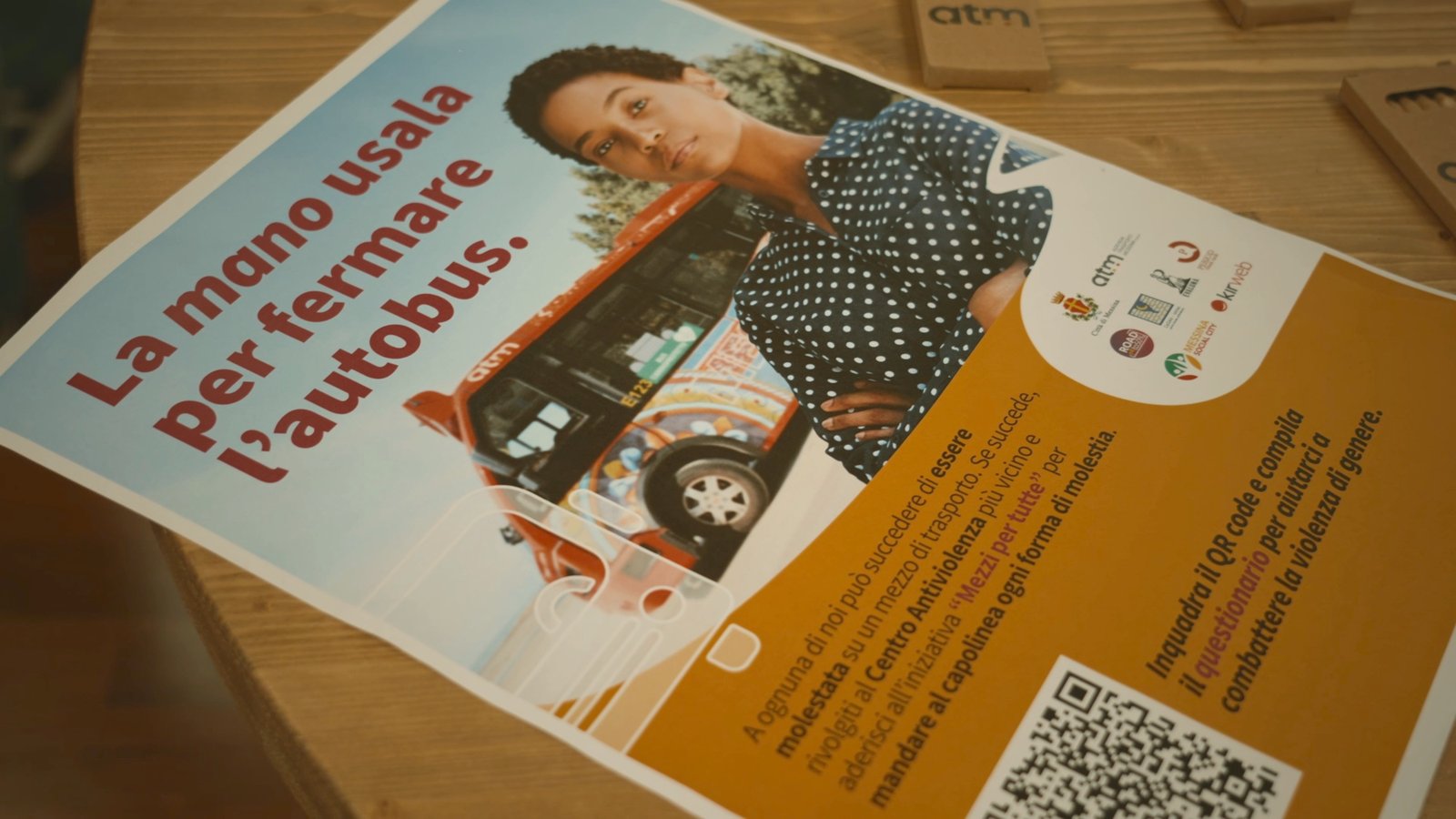 Materiale della campagna sociale con la scritta &laquo;La mano usala per fermare l'autobus&raquo; e un QR code