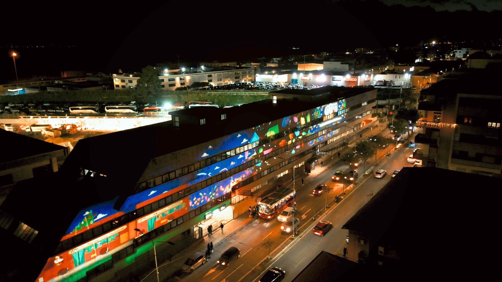 Vista aerea notturna della linea tranviaria ATM Messina illuminata accanto all'asse viario cittadino