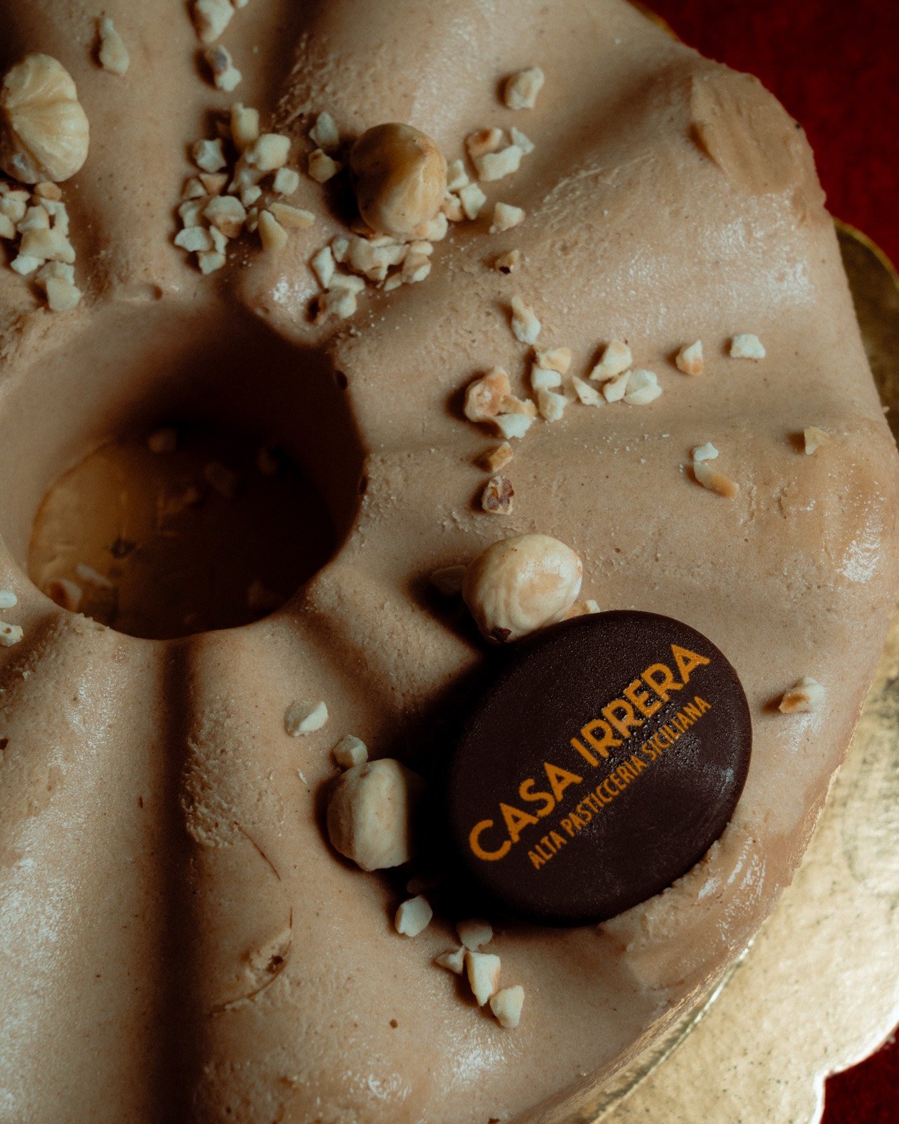 Close-up of a chocolate hazelnut mousse cake with crushed and whole hazelnuts on top