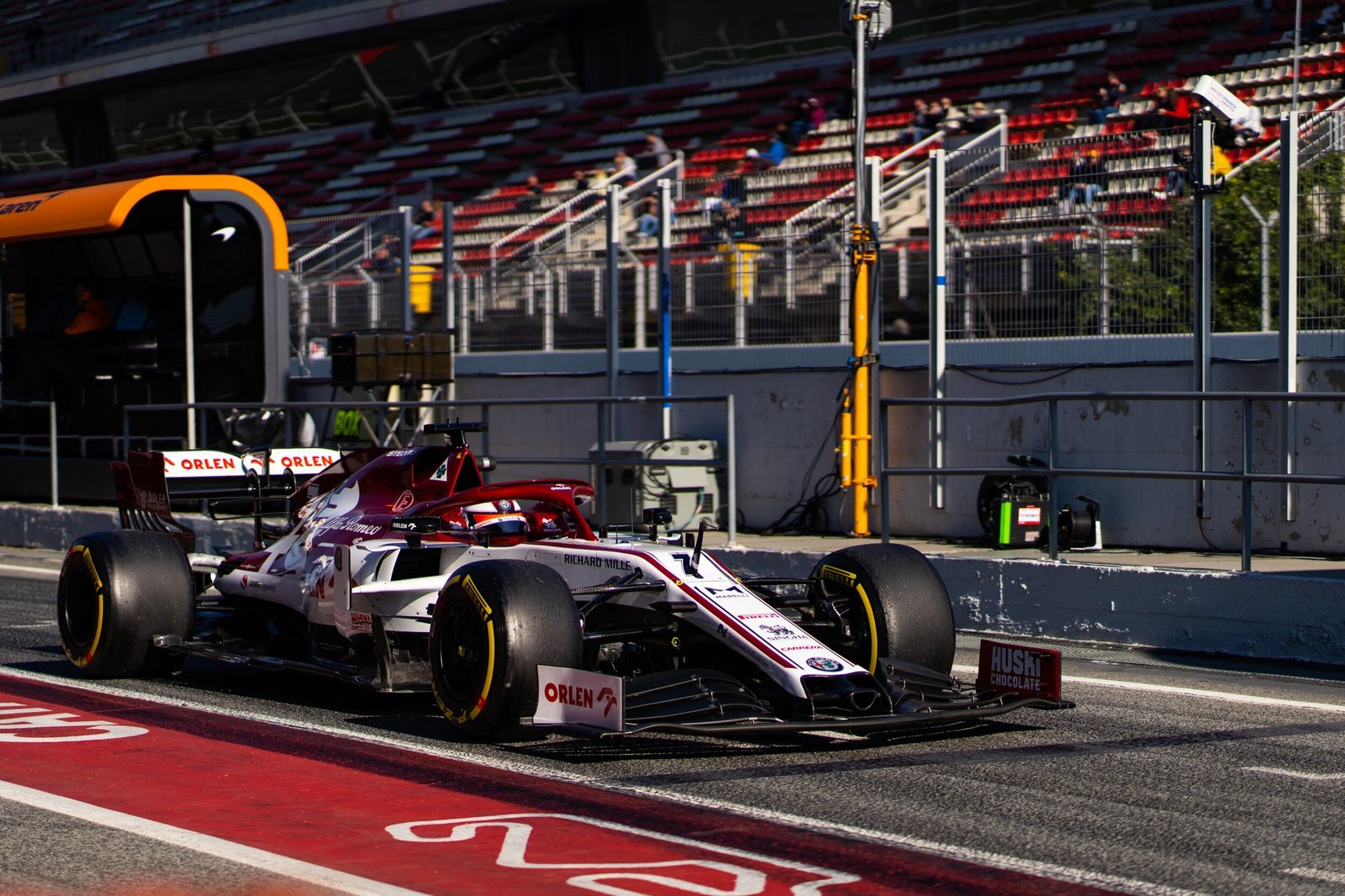 Alfa Romeo Racing C39 number 7 leaving the pit box with the McLaren garage behind, Formula 1 pre-season testing, Barcelona 2020