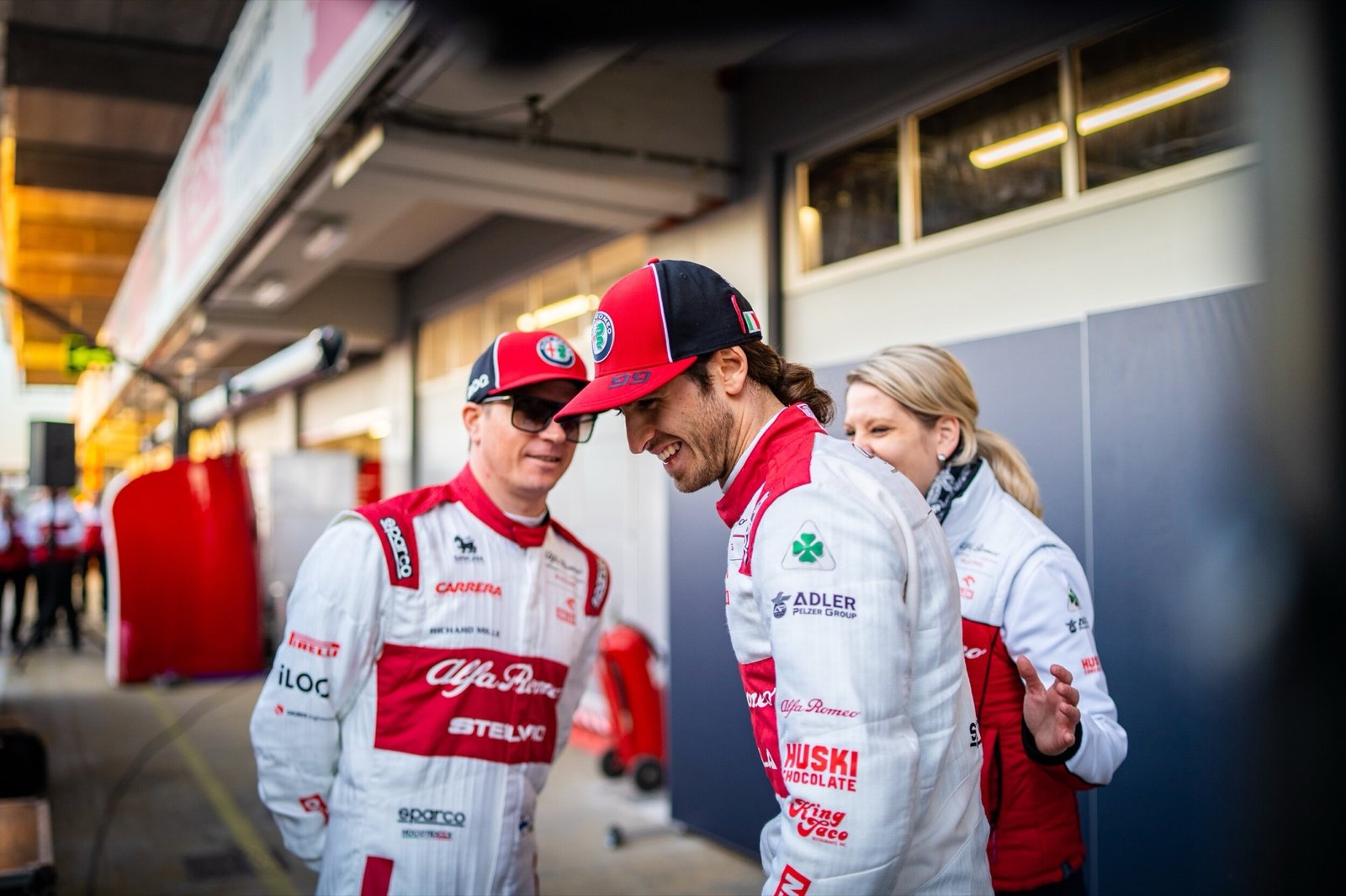 Two Alfa Romeo Racing drivers talking in the pit lane at Formula 1 pre-season testing, Barcelona 2020