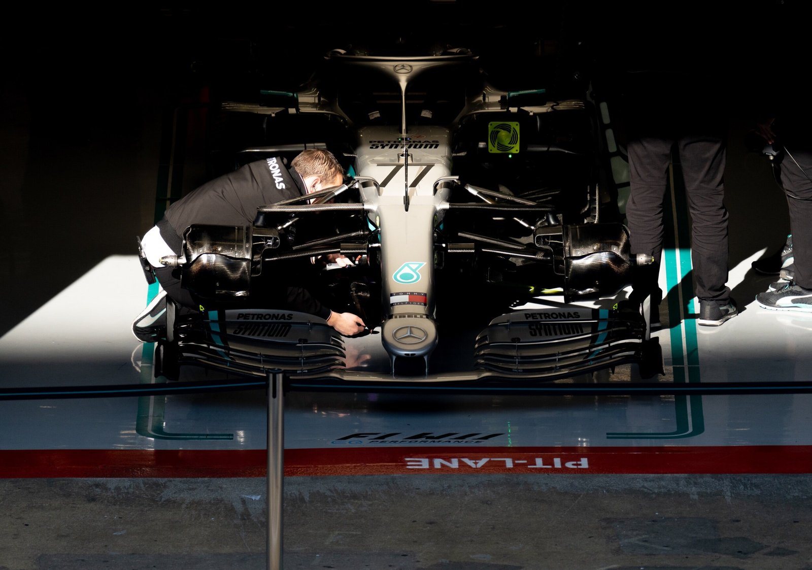 Mercedes W11 number 77 being worked on inside the garage behind the pit lane line, Formula 1 pre-season testing, Barcelona 2020