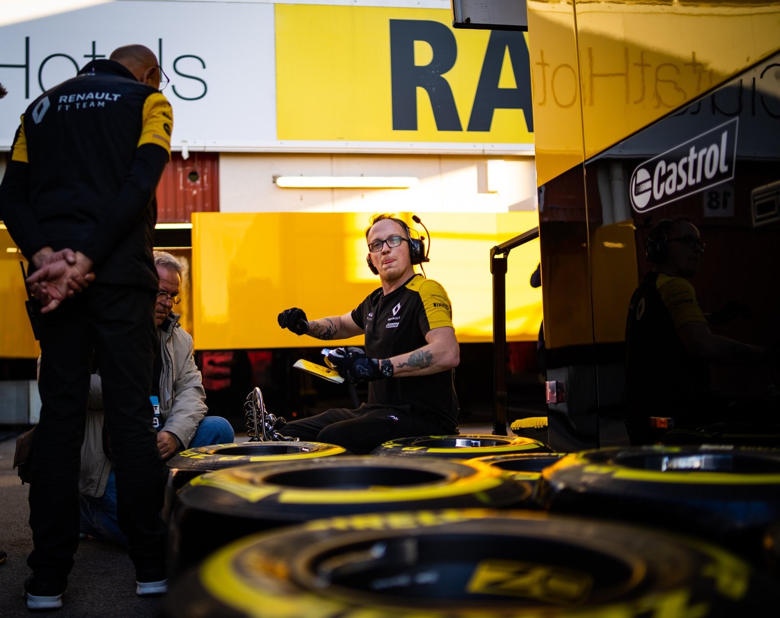 Renault mechanic among Pirelli tyre sets outside the team garage at golden hour, Formula 1 pre-season testing, Barcelona 2020
