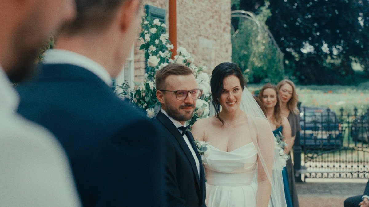 The bride and groom smiling as they walk down the aisle past guests