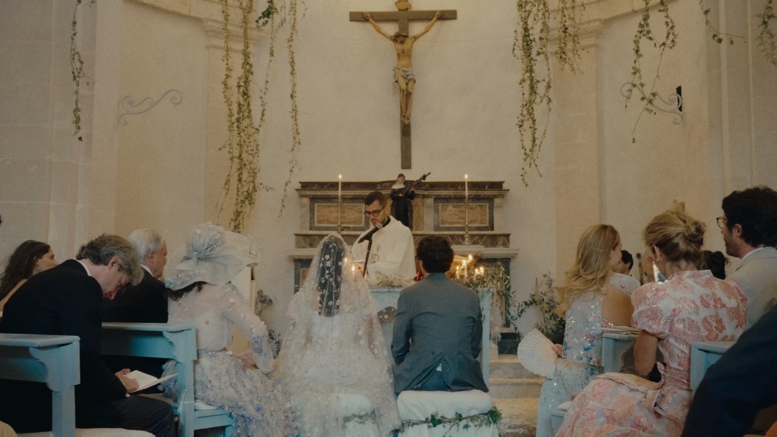 The couple at the altar during the church ceremony, guests seated in the pews