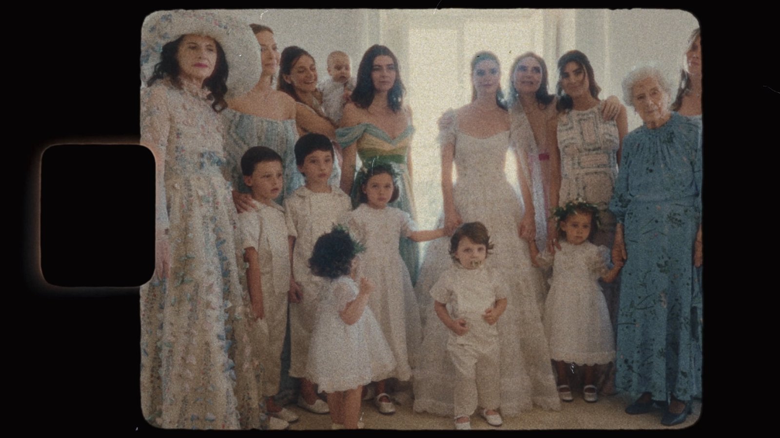 Group portrait of the bridesmaids, flower girls and family, framed as a vintage film still