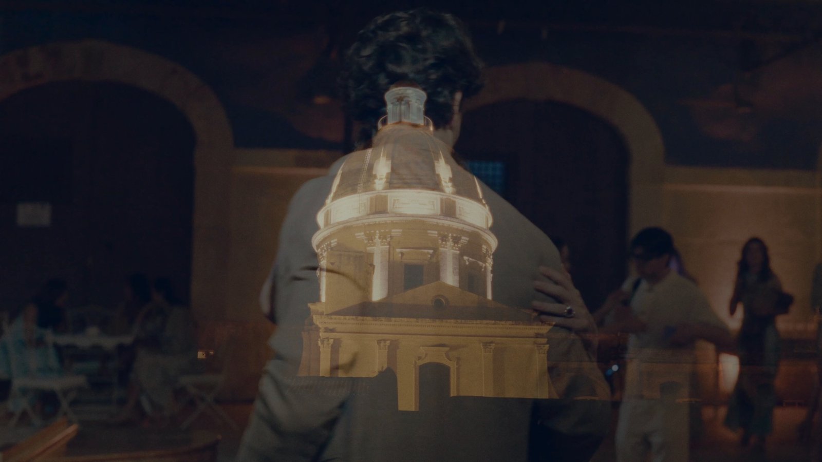 A guest carrying an illuminated model of a domed church through the evening celebration