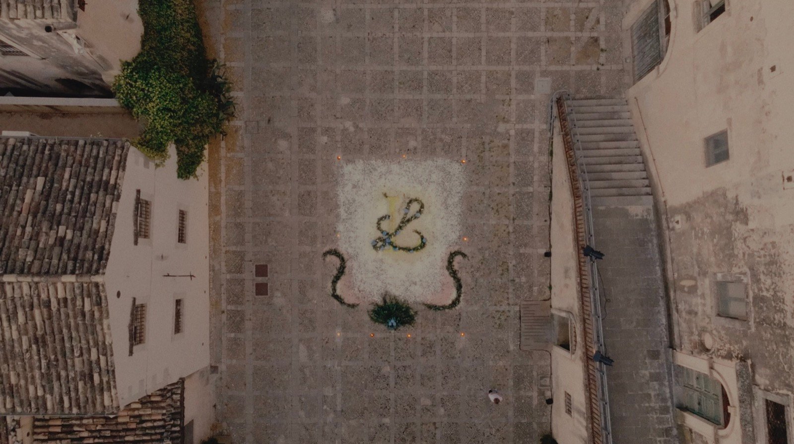 Aerial view of the couple's monogram made from flower petals laid out in the town square