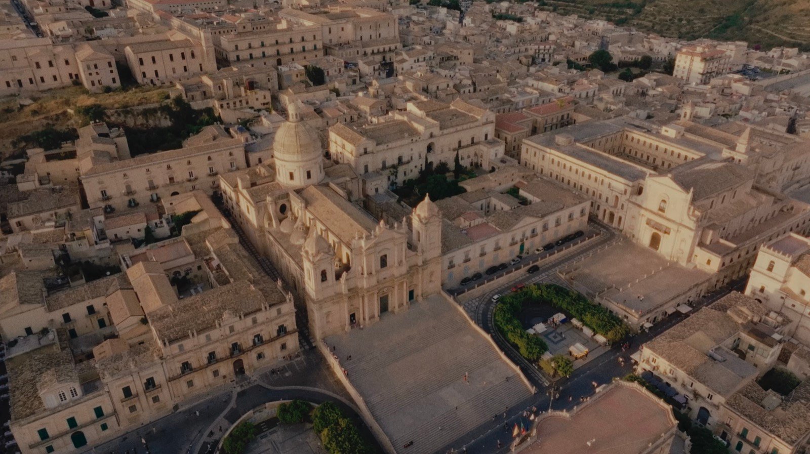 Aerial view of Noto's baroque cathedral and town square at golden hour