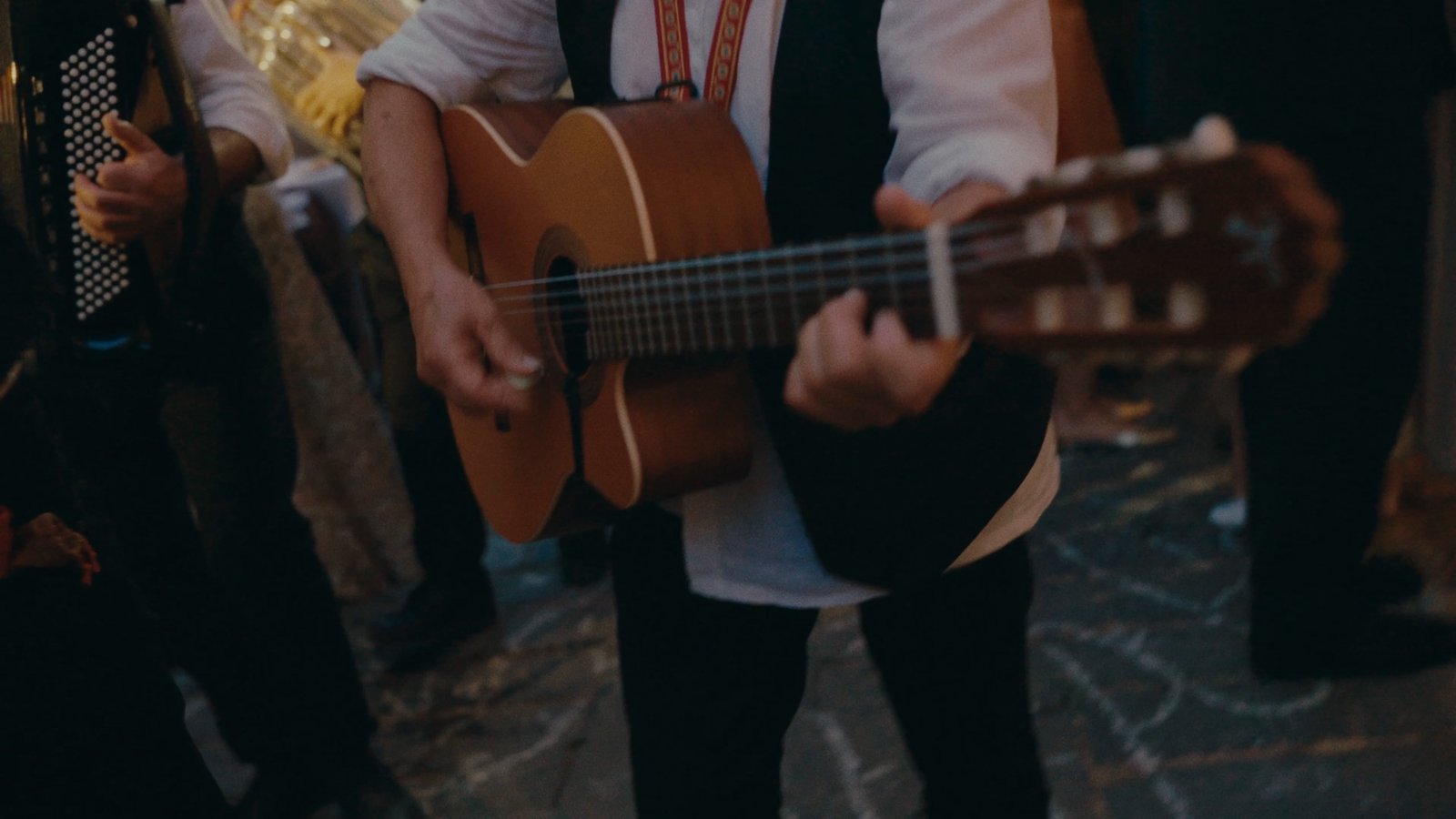 A guitarist and an accordion player performing in the street during the celebration