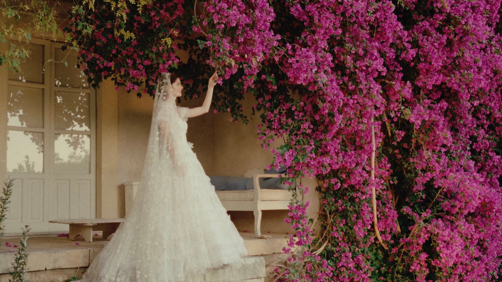 The bride standing beneath a wall of bougainvillea at the villa in Riserva di Vendicari