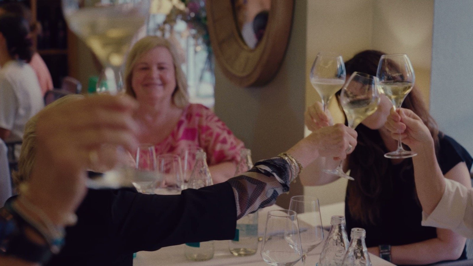 Guests raising glasses in a toast at the White Dinner