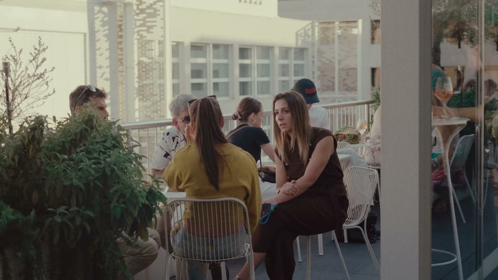 A group in relaxed conversation on a rooftop terrace at the Magna Pars event